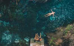 A woman floats in natural body of water 