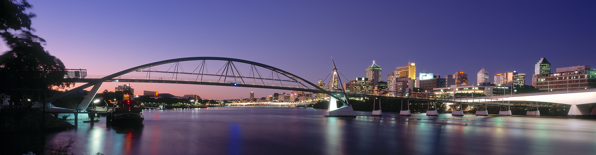 arial view of the Brisbane river with Brisbane city skyline in the background at dusk
