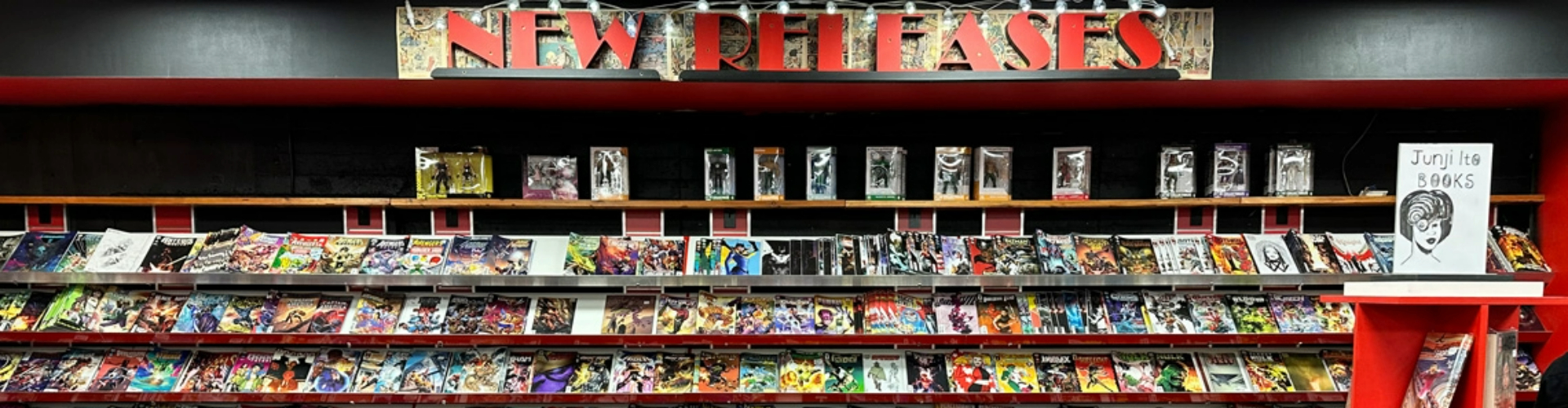 comic-book-display-vic-1920x500 A long, three layered shelf filled with comic books of all kinds.