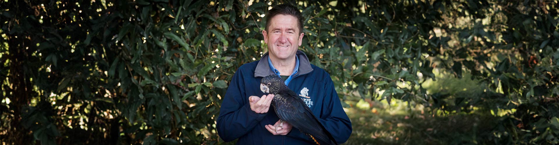 Dr Stephen Van Mil of the Byron Bay Wildlife Hospital holds a black cockatoo