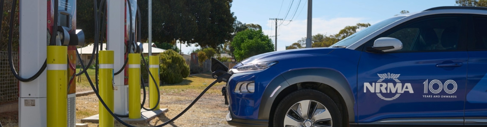 NRMA Wilcannia Charger NRMA EV side view of a blue nrma electric vehicle charging at the nrma charging station in Wilcannia