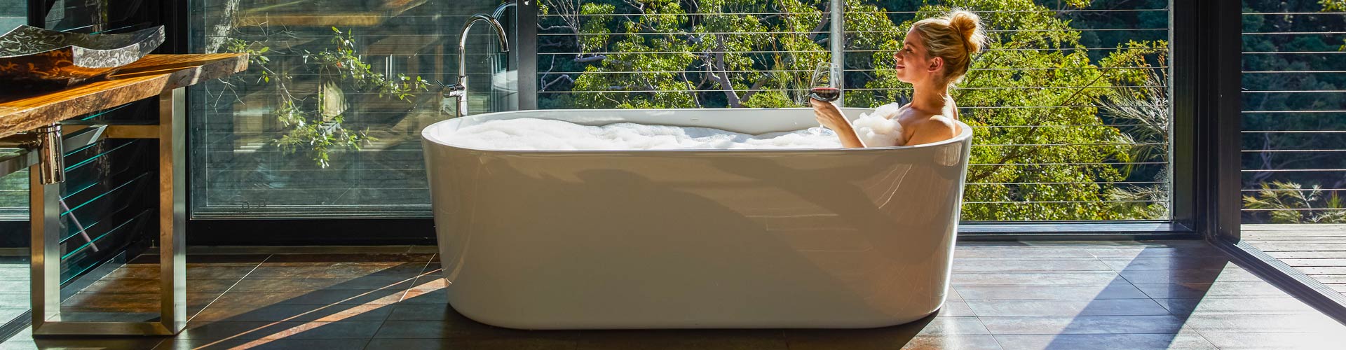 Woman relaxing in the bath with views at Spicers Sangoma Retreat, Bowen Mountain