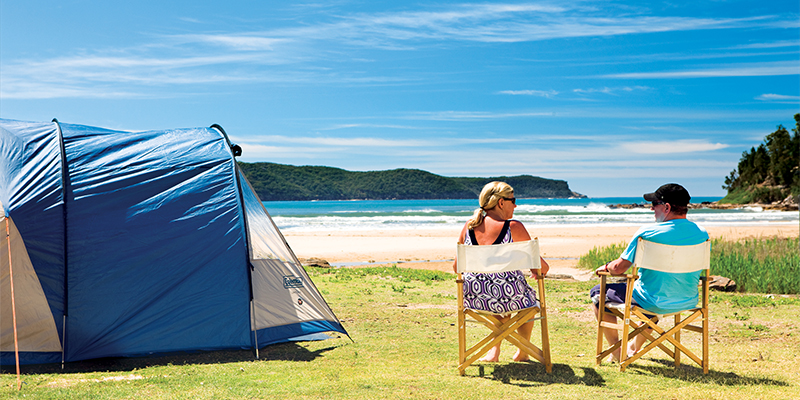 Couple relaxing near tent my nrma road trips Ocean Beach Holiday Resort