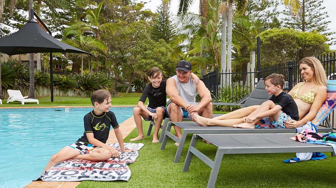family relaxing poolside Port Macquarie Breakwall Holiday Park NSW my nrma local guides