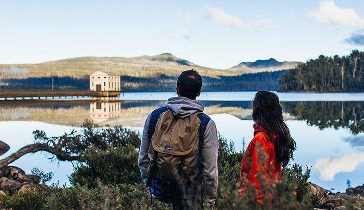 Hikers overlooking Lake St Clair and Pumphouse Point luxury hotel