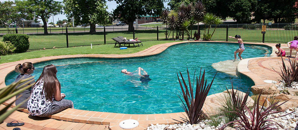 family relaxing poolside Bairnsdale Riverside Holiday Park Victoria my nrma local guides