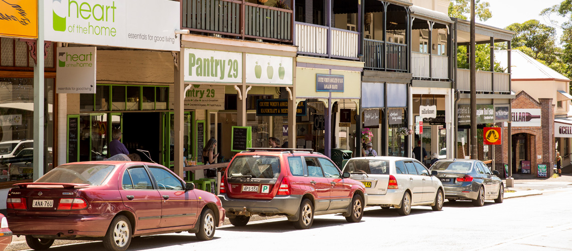 vehicles parked alongside shops in a town