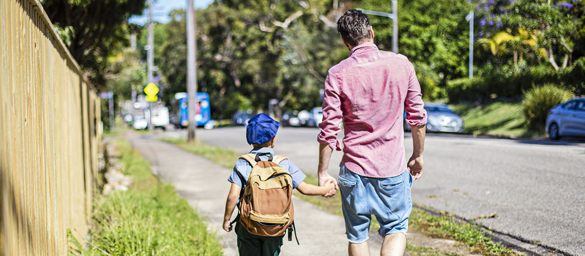 school boy walking with father