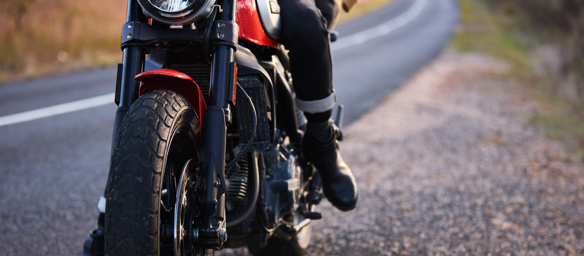 red and black motorcycle parked on the side of the road